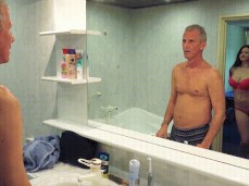 Bella Diamond about to take off bra for old man in hotel bathroom gif