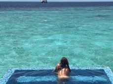 Angel Emily skinny-dipping in beachside pool gif