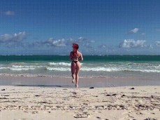 Sweetie Fox in thong bikini runs into the waves gif