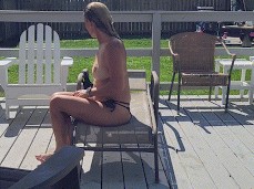 Sexy milf takes off bikini top at backyard pool gif