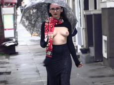 Goth exhibitionist walking down street topless with umbrella gif