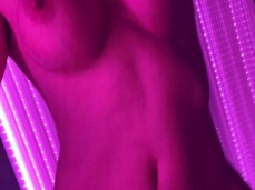 brunette squeezing big boobs and showing pussy in tanning bed gif