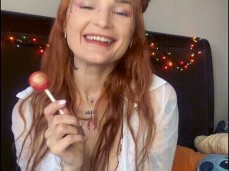 Red-haired nymphomaniac with big tits sucks a lollipop and jerks off gif