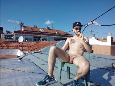 Sexy, lean, uncut Spanish dude sits bucked naked sun bathing on his rooftop gif
